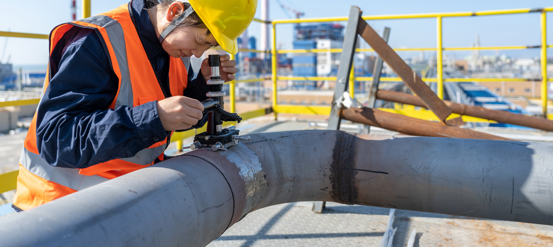 Female engineer inspecting a pipe outdoors